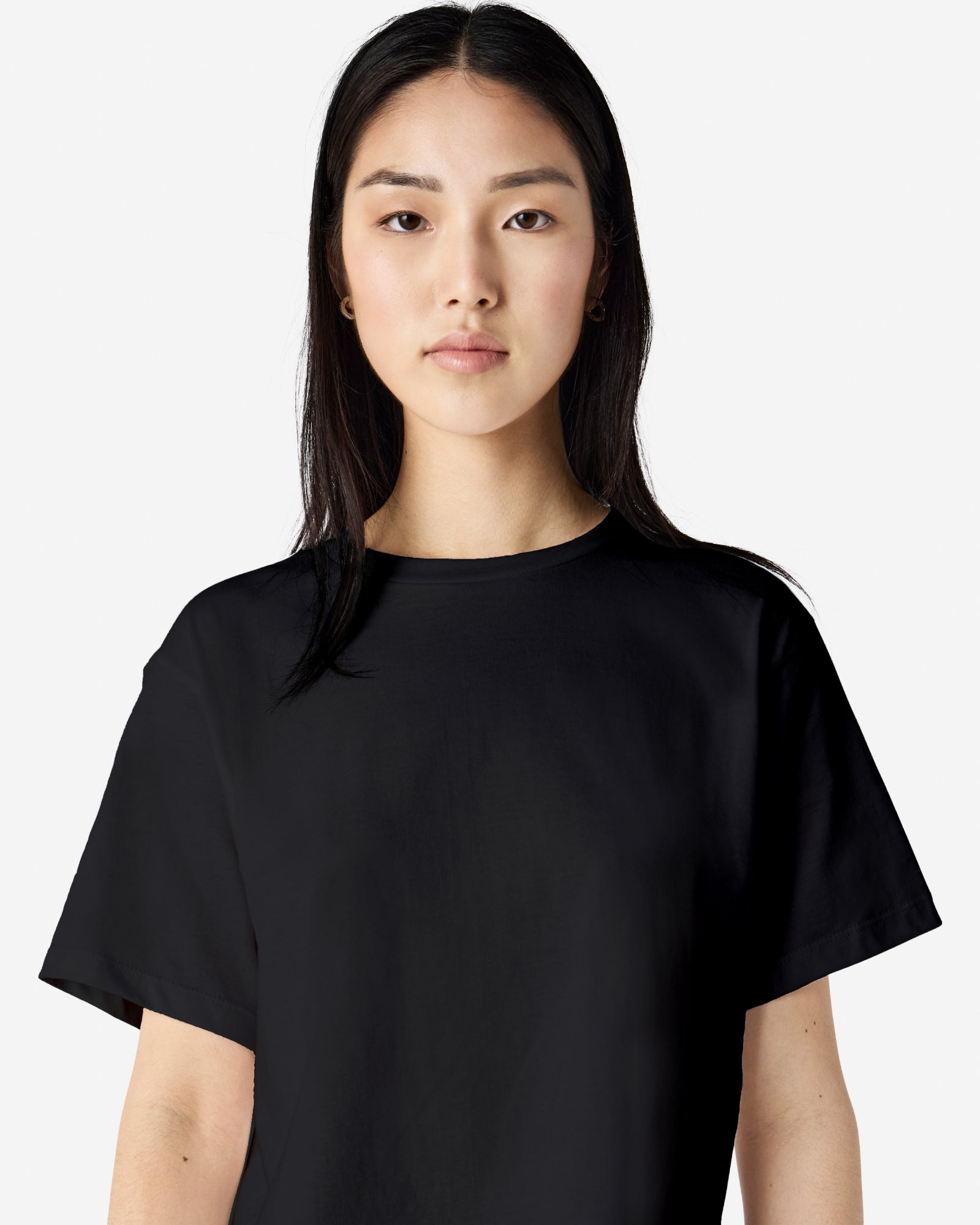 Female model wearing an American Apparel Fine Jersey Women's Boxy Tee in Black, paired with blue jeans, standing against a plain background (front pose) -black