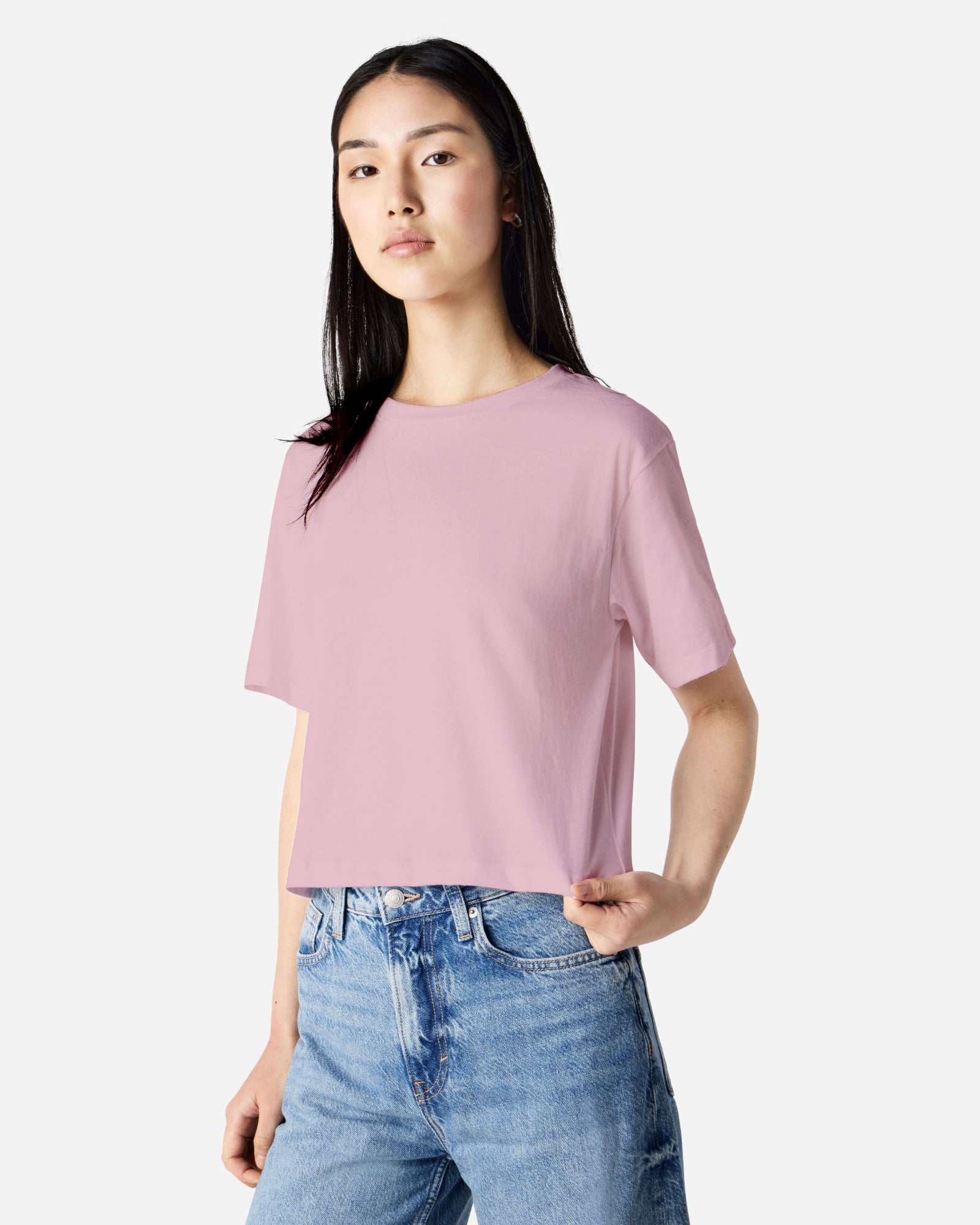 Female model wearing an American Apparel Fine Jersey Women's Boxy Tee in Blush, paired with blue jeans, standing against a plain background (front pose) -blush