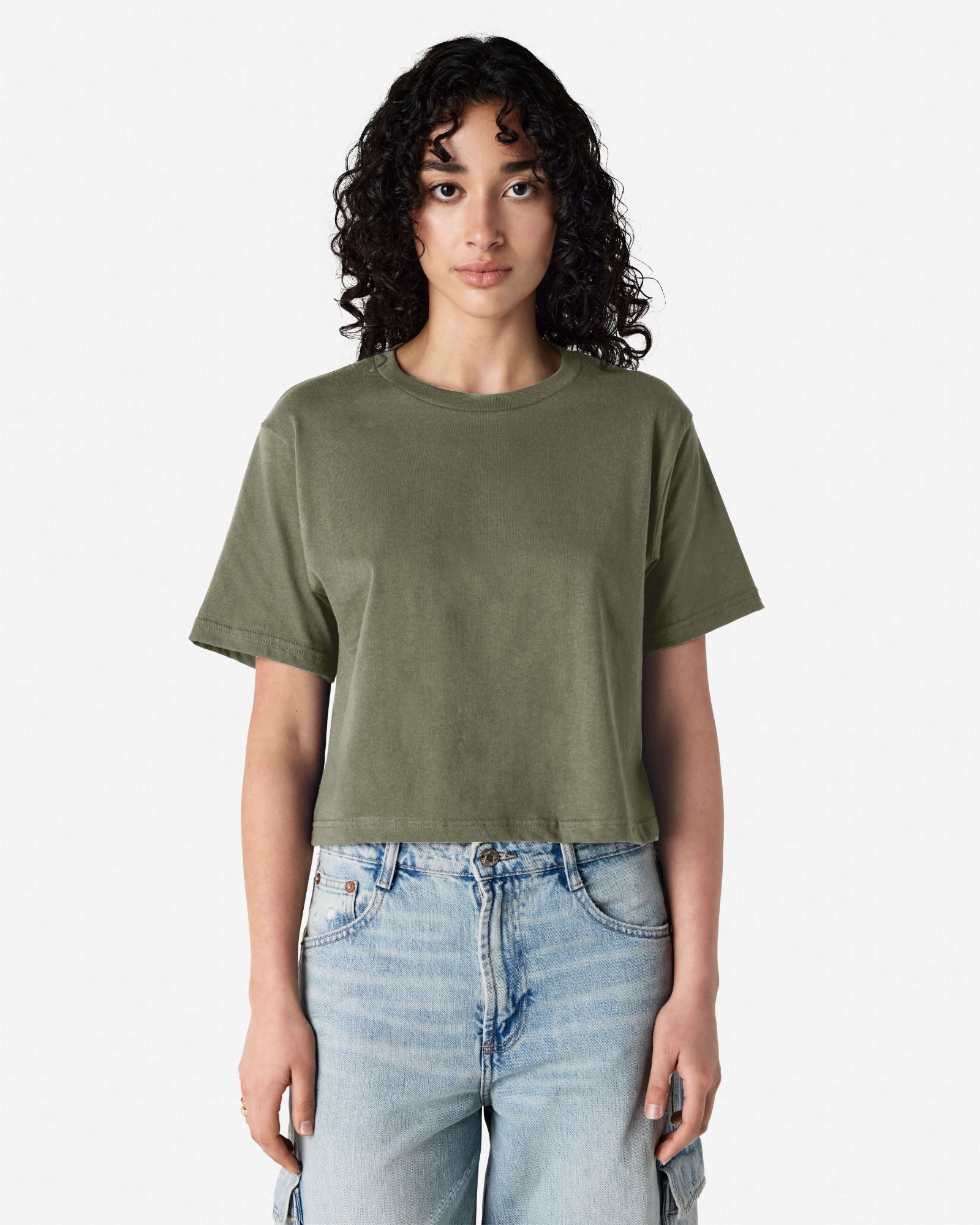 Female model wearing an American Apparel Fine Jersey Women's Boxy Tee in Liuetenant, paired with blue jeans, standing against a plain background (front pose) -liuetenant