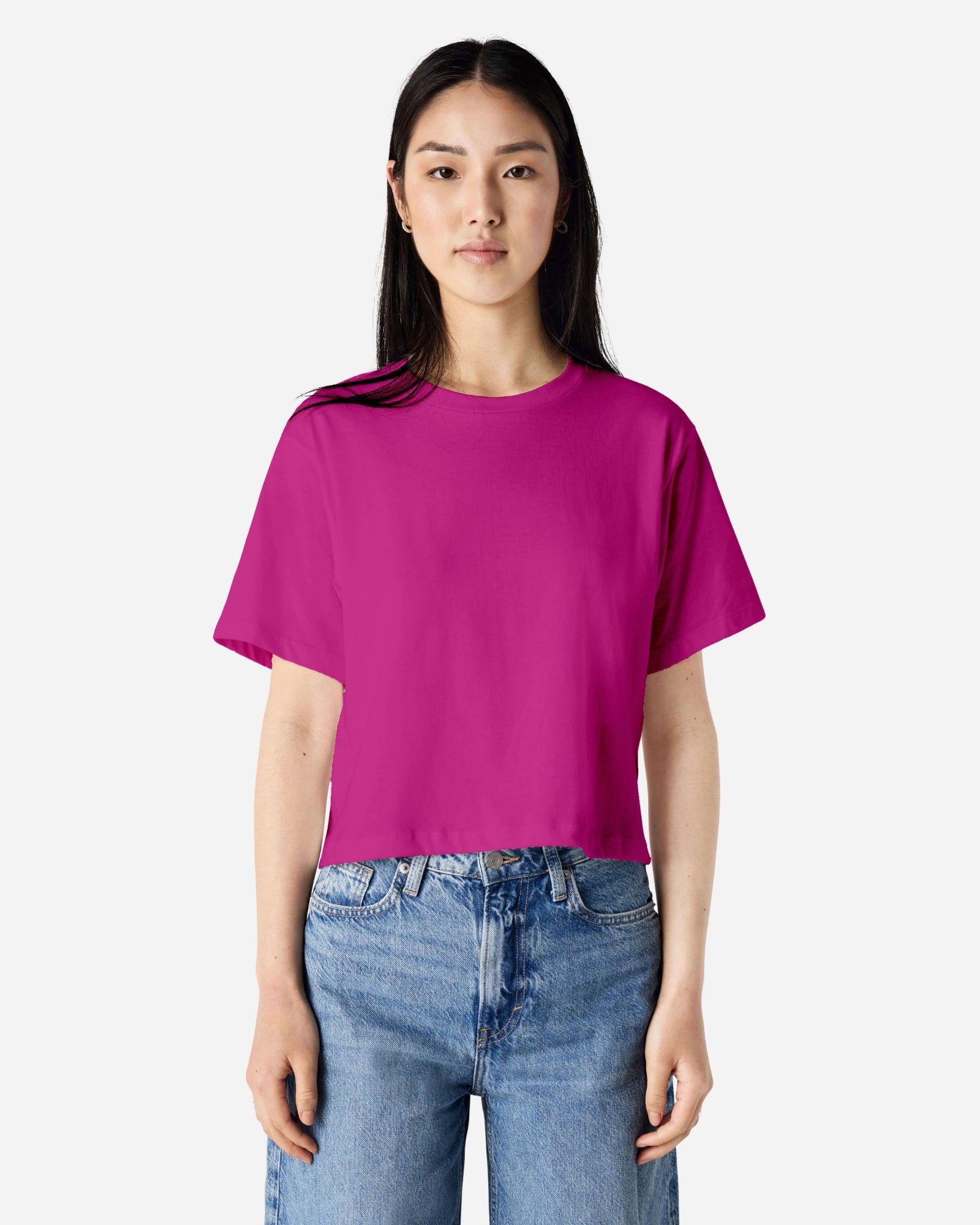 Female model wearing an American Apparel Fine Jersey Women's Boxy Tee in Super Pink, paired with blue jeans, standing against a plain background (front pose) -super pink