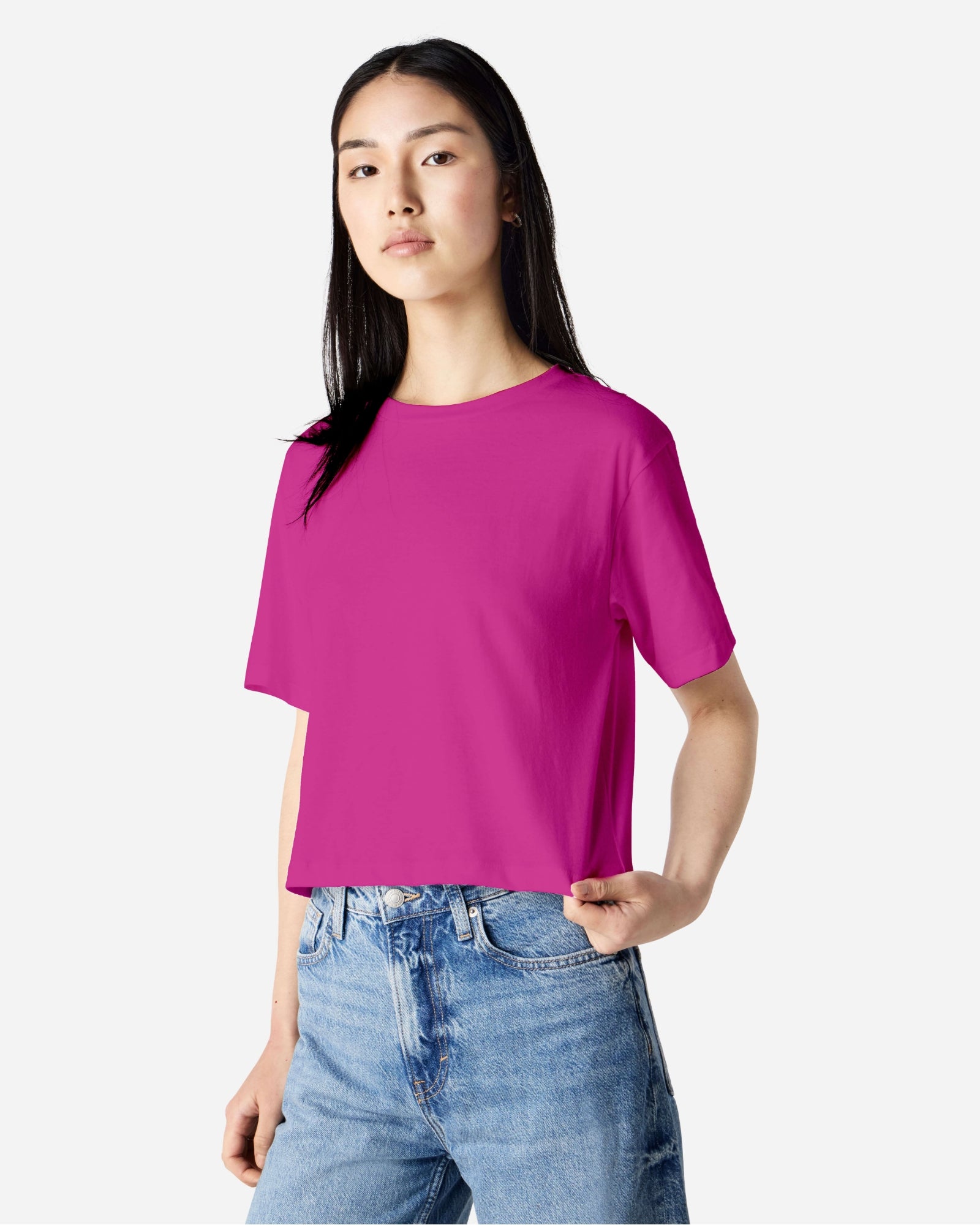 Female model wearing an American Apparel Fine Jersey Women's Boxy Tee in Super Pink, paired with blue jeans, standing against a plain background (front pose) -super pink