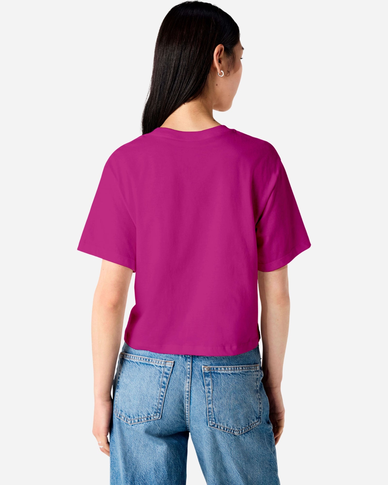 Female model wearing an American Apparel Fine Jersey Women's Boxy Tee in Super Pink, paired with blue jeans, standing against a plain background (back pose) -super pink