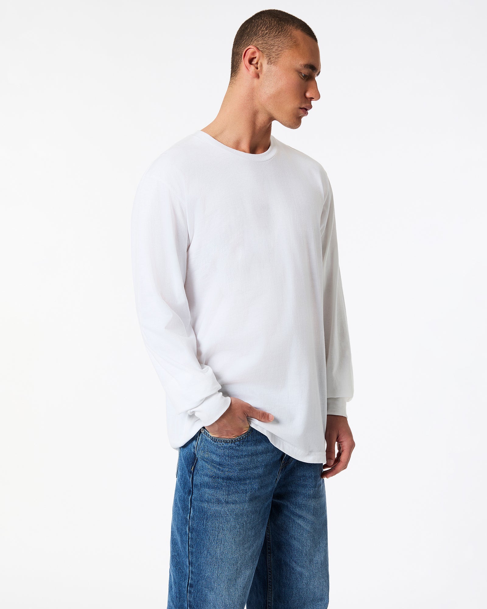 male model wearing American Apparel white Colour Fine Jersey Unisex Long Sleeve Crew Neck T-shirt- side pose