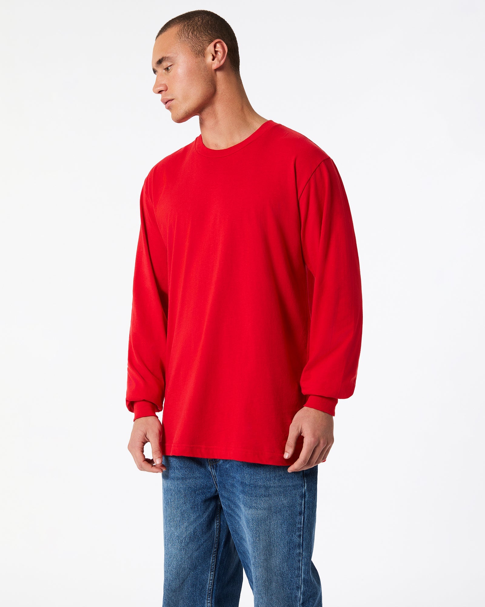 male model wearing American Apparel Red Colour Fine Jersey Unisex Long Sleeve Crew Neck T-shirt- Side pose