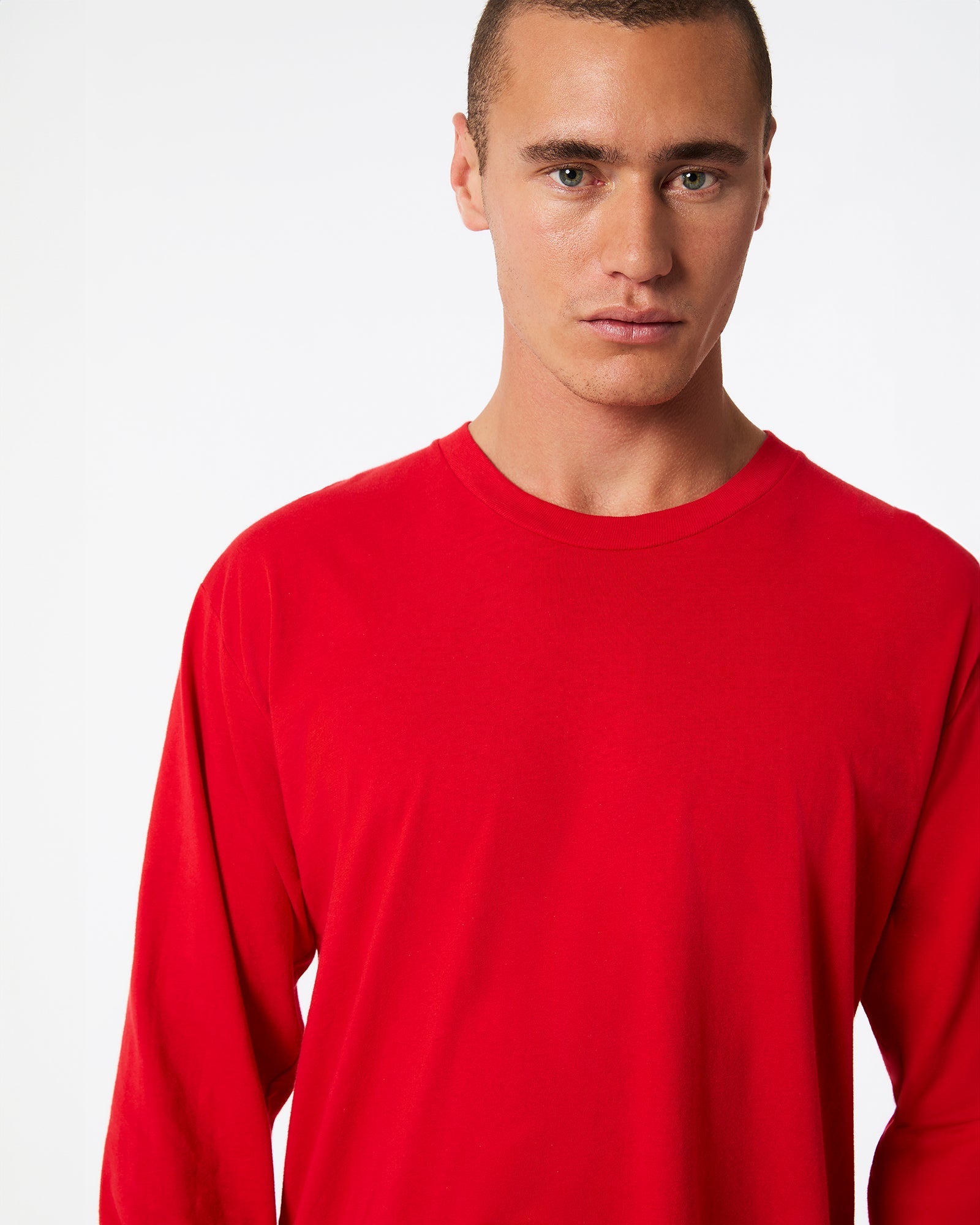 male model wearing American Apparel Red Colour Fine Jersey Unisex Long Sleeve Crew Neck T-shirt- half Front pose