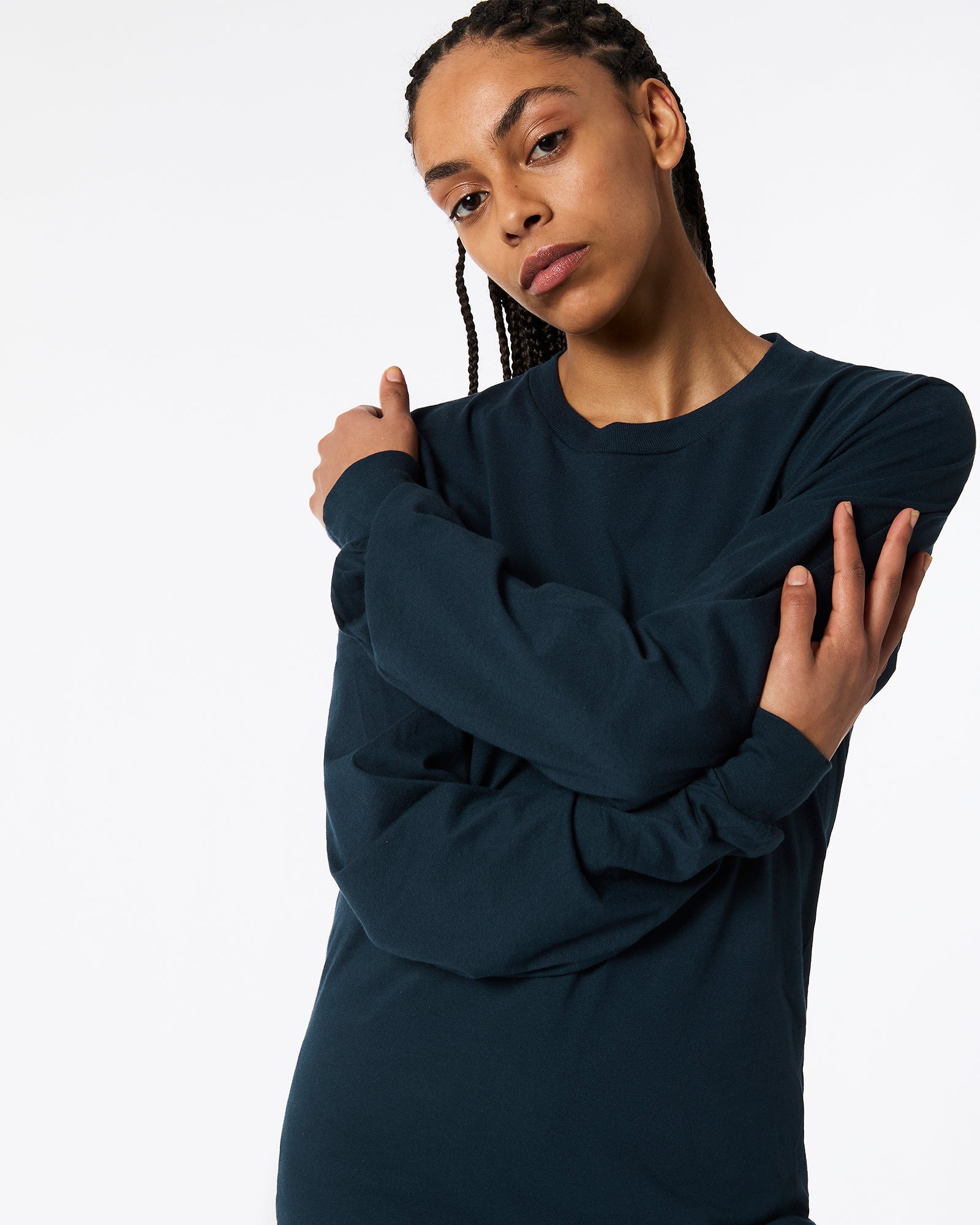 Female model wearing American Apparel Navy Colour Fine Jersey Unisex Long Sleeve Crew Neck T-shirt- cross hands pose