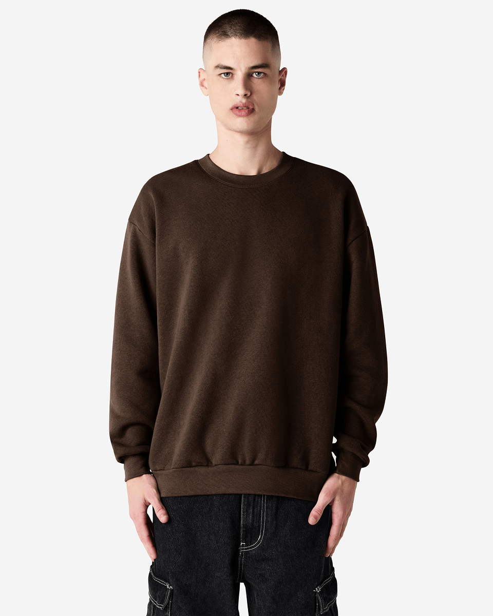 Male model wearing a Reflex Unisex Crewneck Sweatshirt (front pose) -brown