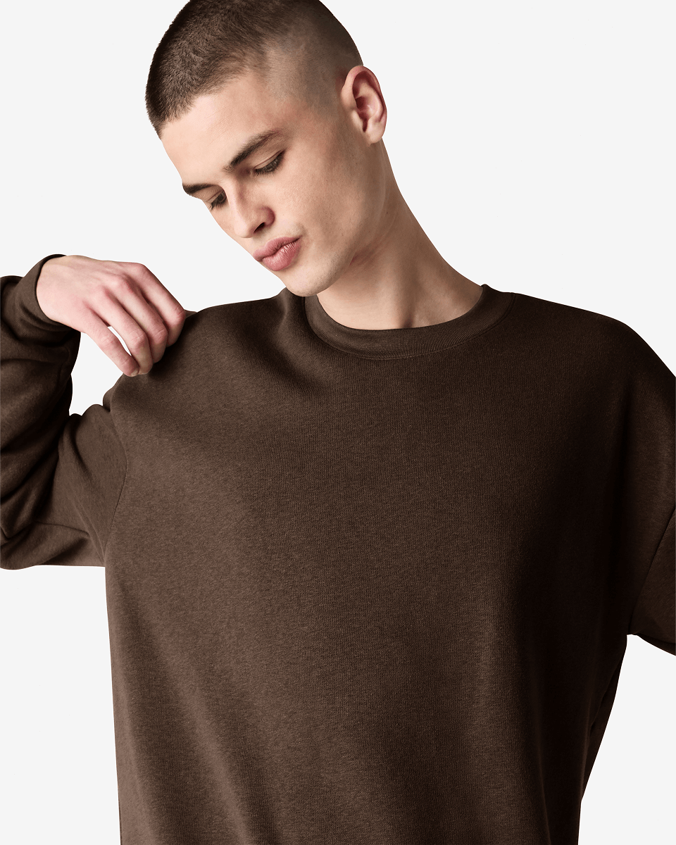 Male model wearing a Reflex Unisex Crewneck Sweatshirt (front pose) -brown